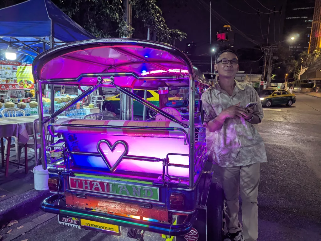 Tuk tuk driver next to tuk tuk